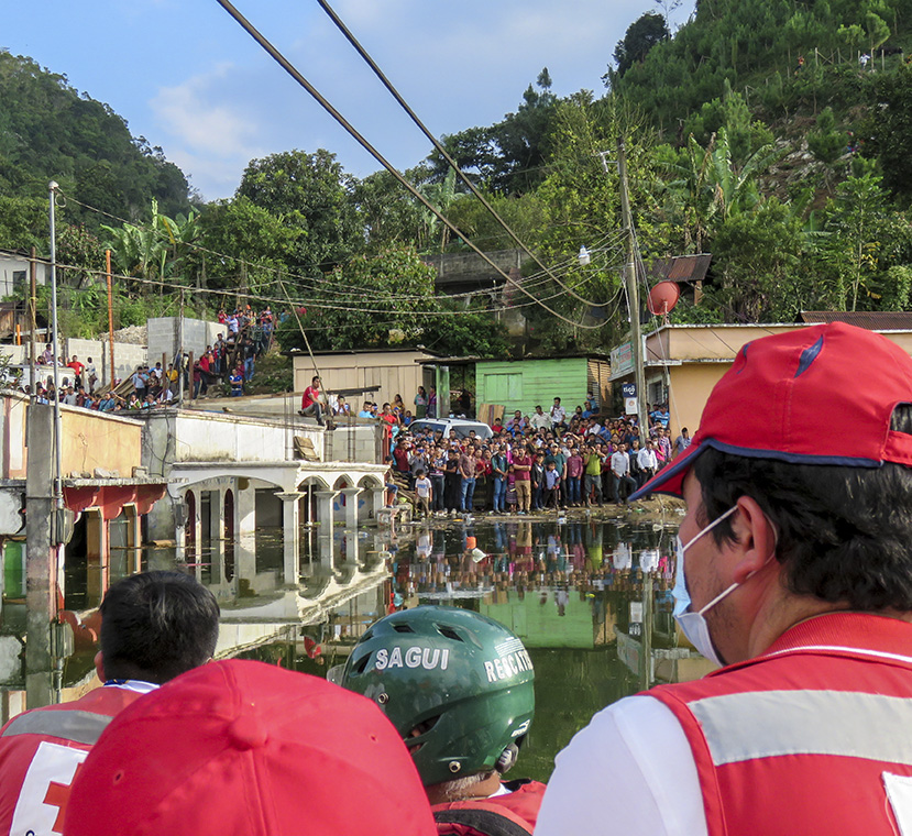 Población de Campur se aglomera a la orilla de una zona inundada en el centro del pueblo para recibir la ayuda humanitaria de los rescatistas de la Cruz Roja Guatemalteca, el 15 de noviembre. Juana Guerrero