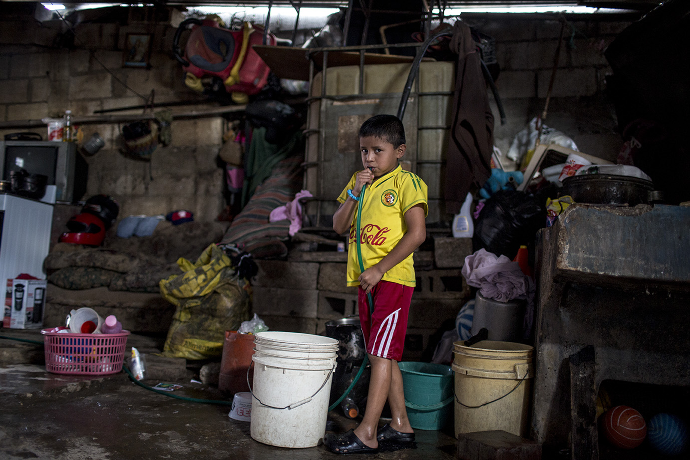Mario Quijú, 8, aspira aire por una manguera para empezar a llenar las cubetas de su casa, ubicada en el lote 18 sector A de la colonia Candelaria, en la tarde del lunes 04 de noviembre 2019. Simone Dalmasso