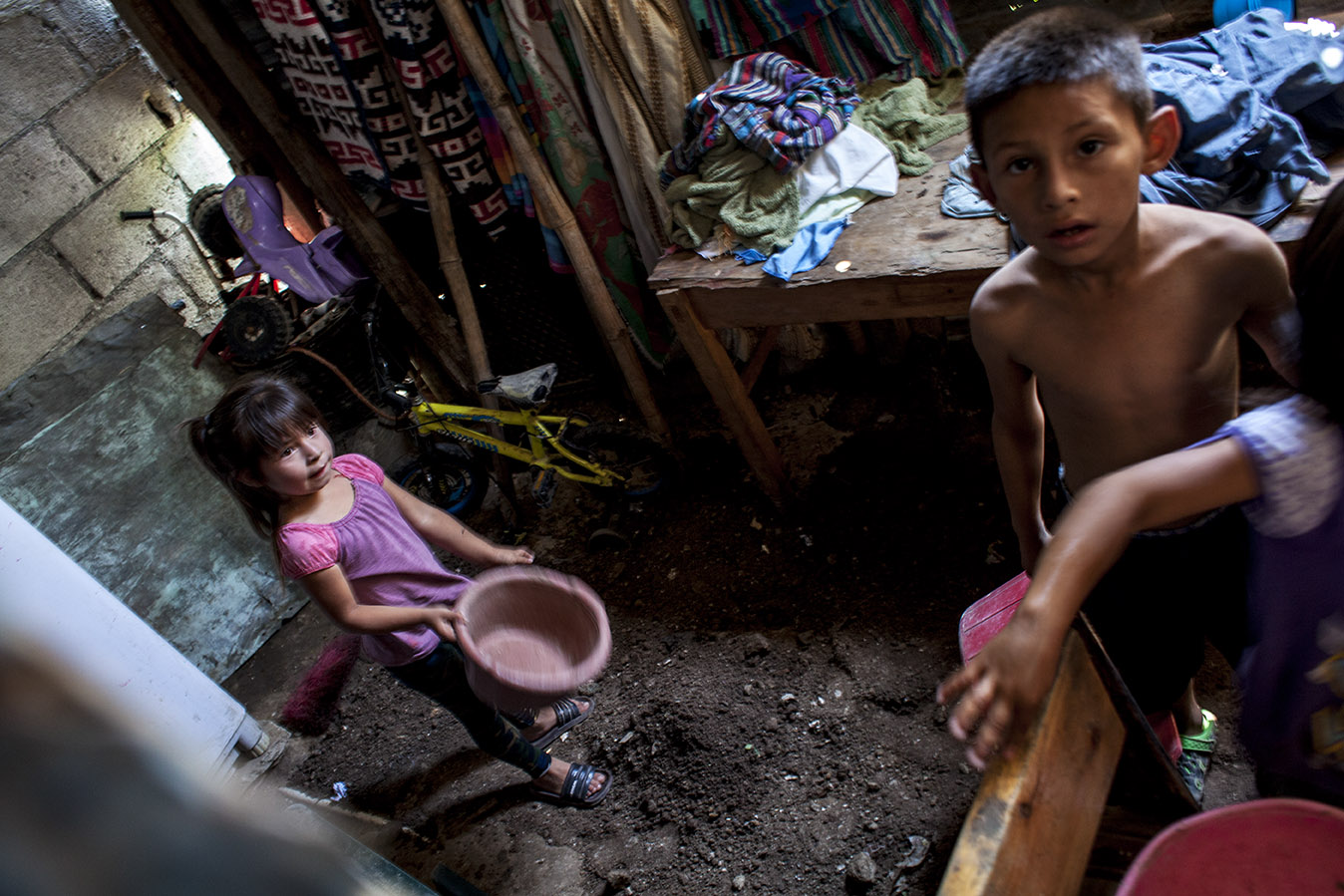 En la casa de Caterín, los menores de sus 6 hijos rellenando con tierra un hoyo que el agua creó después de las fuertes lluvias de los días anteriores, en octubre 2019. Simone Dalmasso