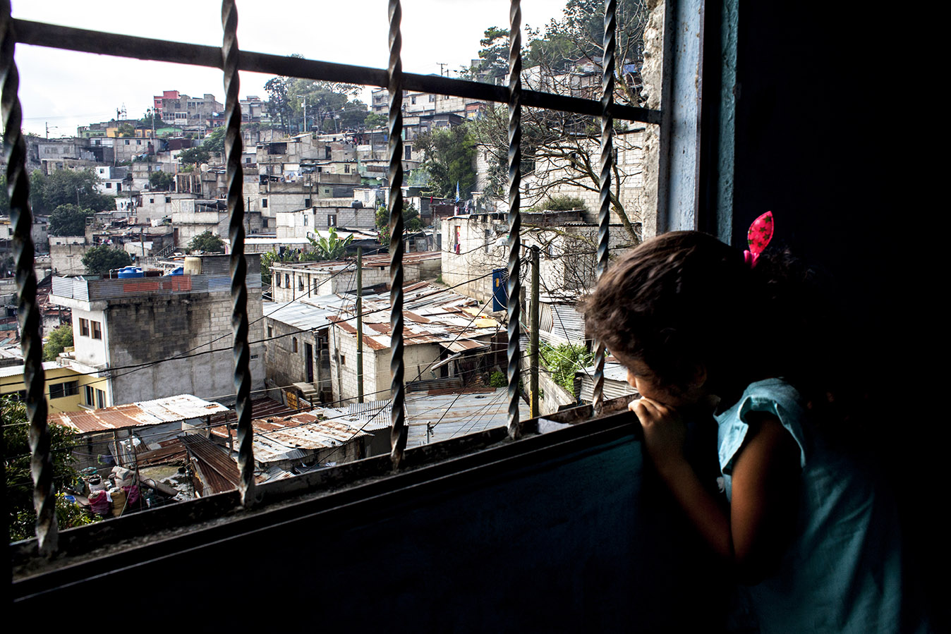 Samantha López, 4, una de los 19 nietos de Odilia López, observa el panorama de casas de block y láminas que conforman el barrio de la Candelaria, donde vive con la abuela, un día de lluvia en octubre 2019. Simone Dalmasso 