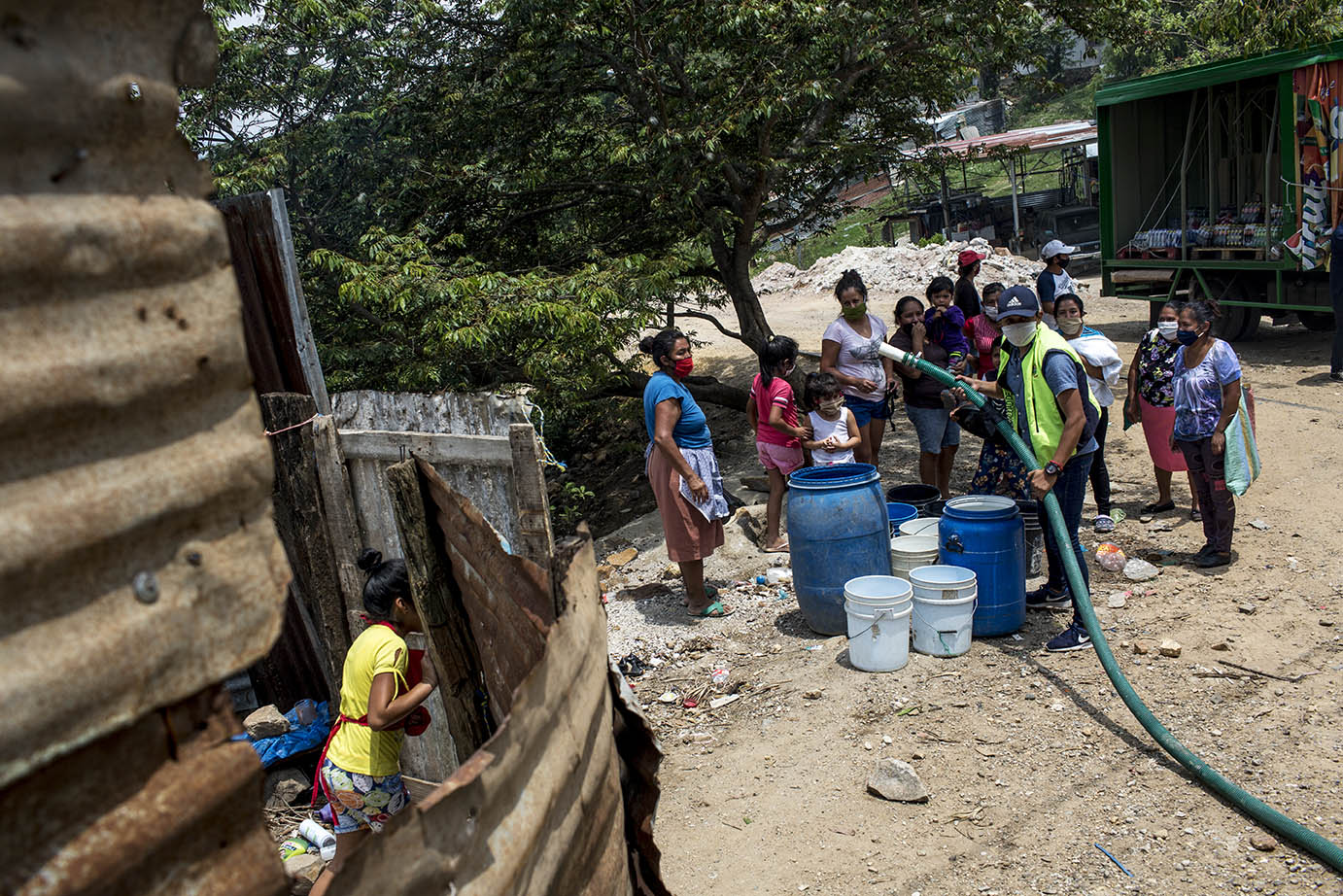 Un grupo de mujeres reciben la llegada de una cisterna de Empagua en la ladea Lo de Rodríguez, sector 2 Vuelta Grande, área periférica de la zona 18, el martes 19 de mayo 2020. Simone Dalmasso
