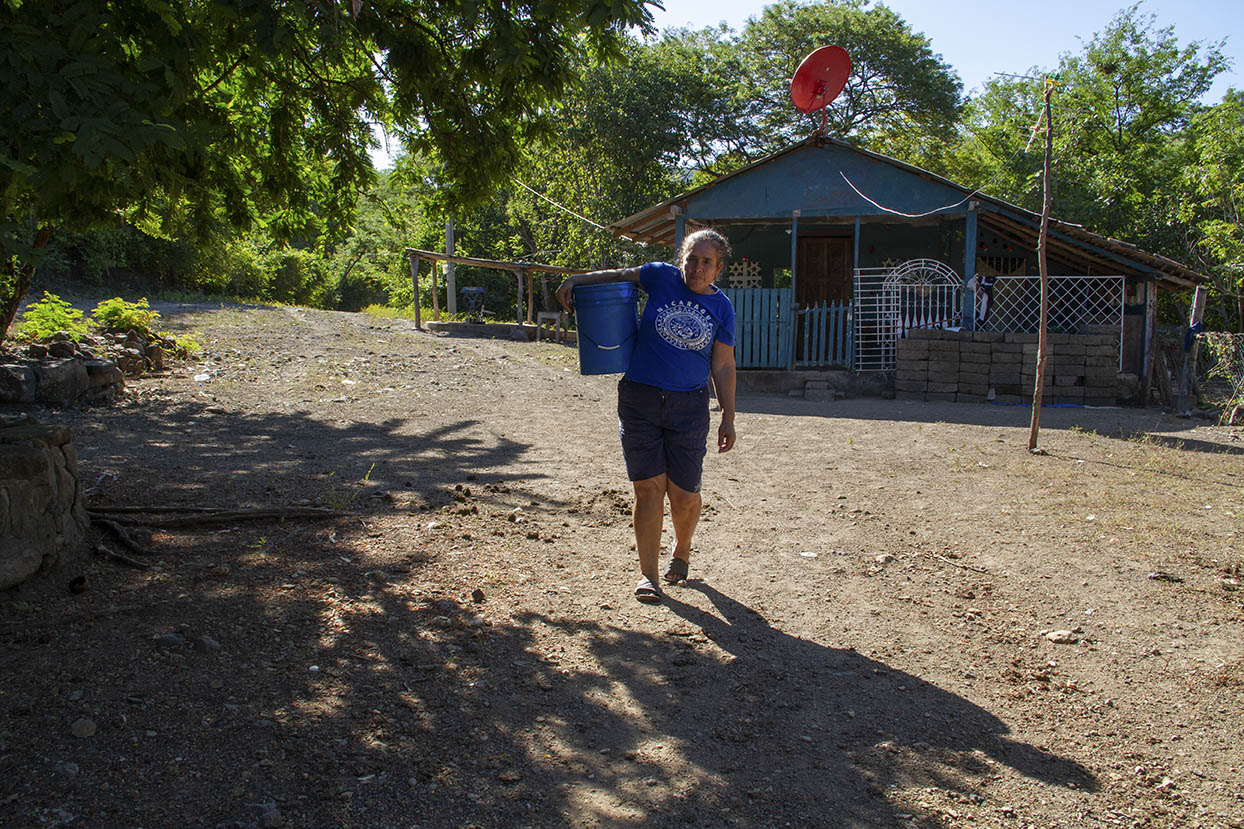 María Tomasa Obando carga un balde con agua para uso doméstico. Margarita Montealegre