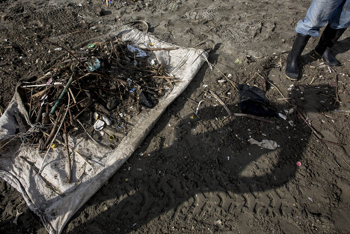 La silueta de un recolector de basura del MARN, por la mañana del miércoles 6 de noviembre, en la playa de El Quetzalito. Simone Dalmasso