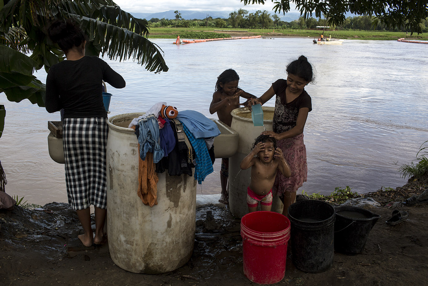 Carla Tobar, 18, lava la ropa a la orilla del río Motagua, en el Quetzalito, mientras su cuñada, Dora, baña a su hija Ánderlin. Simone Dalmasso