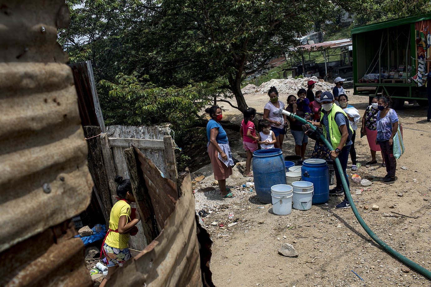 Un grupo de mujeres reciben la llegada de una cisterna de Empagua en la ladea Lo de Rodríguez, sector 2 Vuelta Grande, área periférica de la zona 18, el martes 19 de mayo 2020. Simone Dalmasso