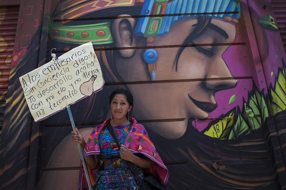 Una mujer indígena enseña un cartel de protesta que responsabiliza al sector empresarial del país por el desvío de ríos, durante la marcha del agua de 2016. Simone Dalmasso